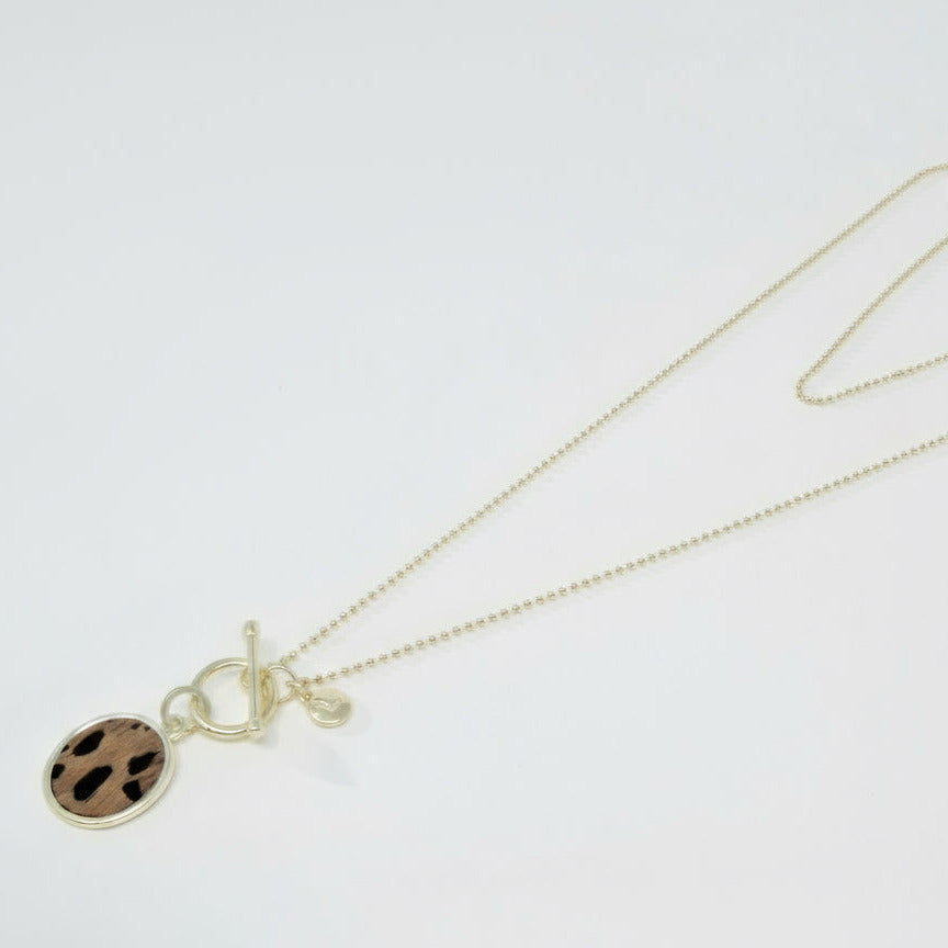 Gold necklace with a round pendant leopord print disc pendant.