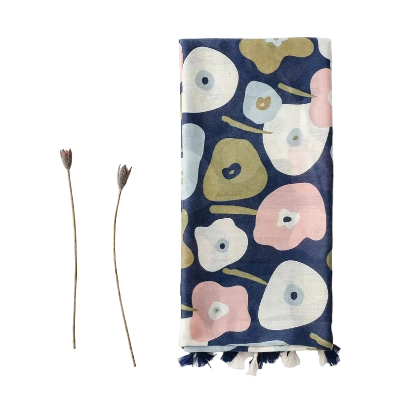Floral patterned towel with tassels on a white background