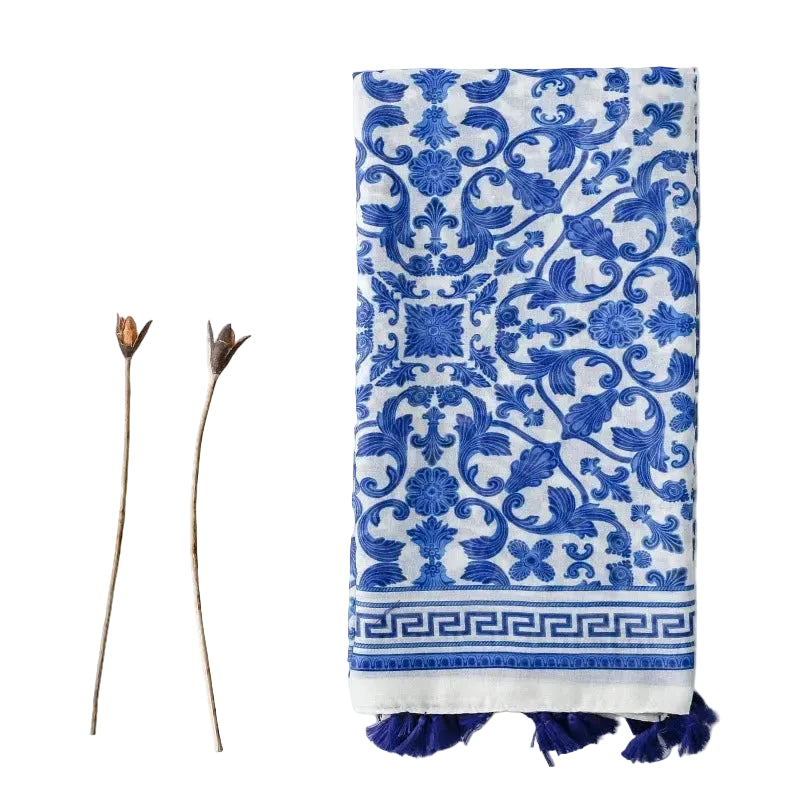 Blue and white patterned towel with fringe on a white background