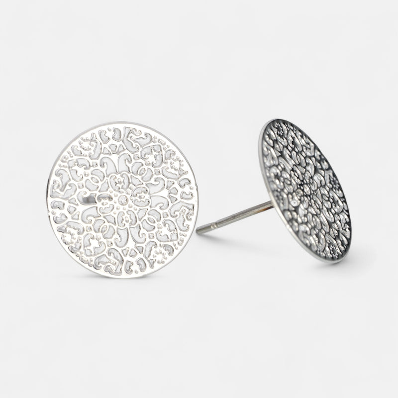 Silver round earrings with intricate designs on a light gray background